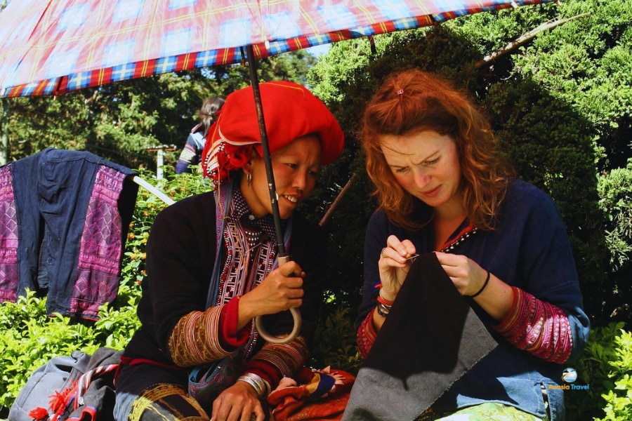Red Dao woman teaching embroidery to tourist in Sapa Vietnam – Auasia Travel